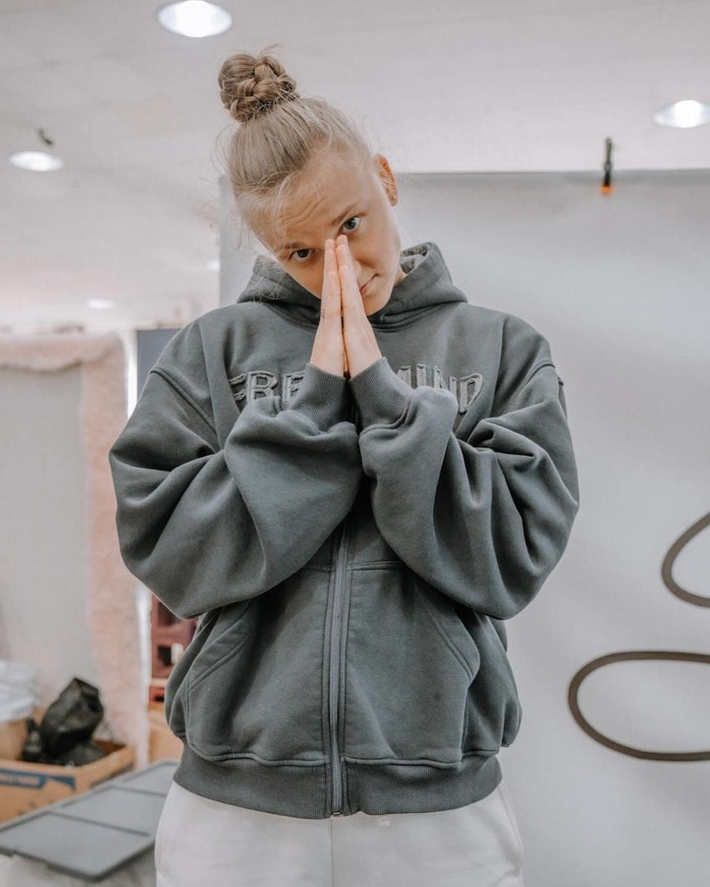 Model wearing grey “Free Mind” zip-up hoodie from ENDEN BRAND, front view showing affirmation design and minimalist streetwear style.