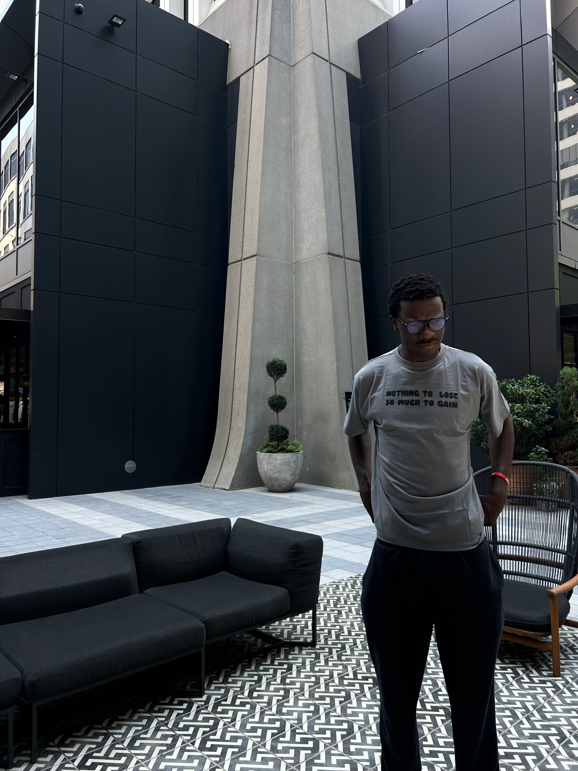 Model wearing dark grey ENDEN BRAND t-shirt styled in relaxed, casual outfit