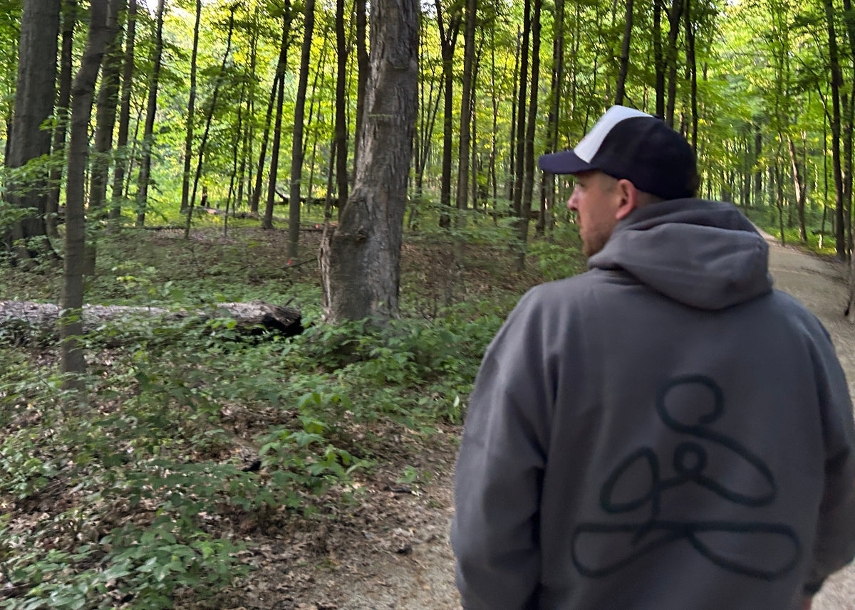 Tomas standing in a forest wearing ENDEN BRAND