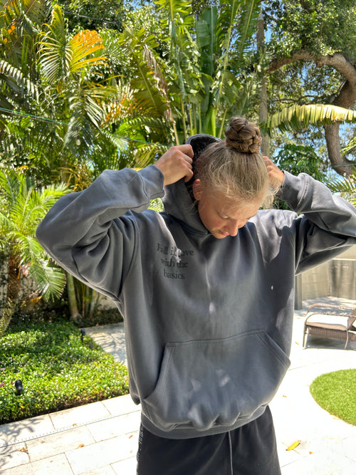 Model wearing grey “Fall in Love with the Basics” hoodie from ENDEN BRAND, styled as minimalist, affirmation-based streetwear.