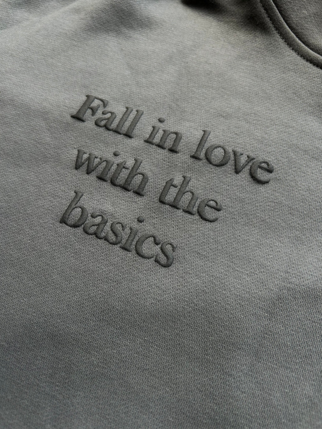 Close-up of puff print text “fall in love with the basics” on ENDEN BRAND hoodie